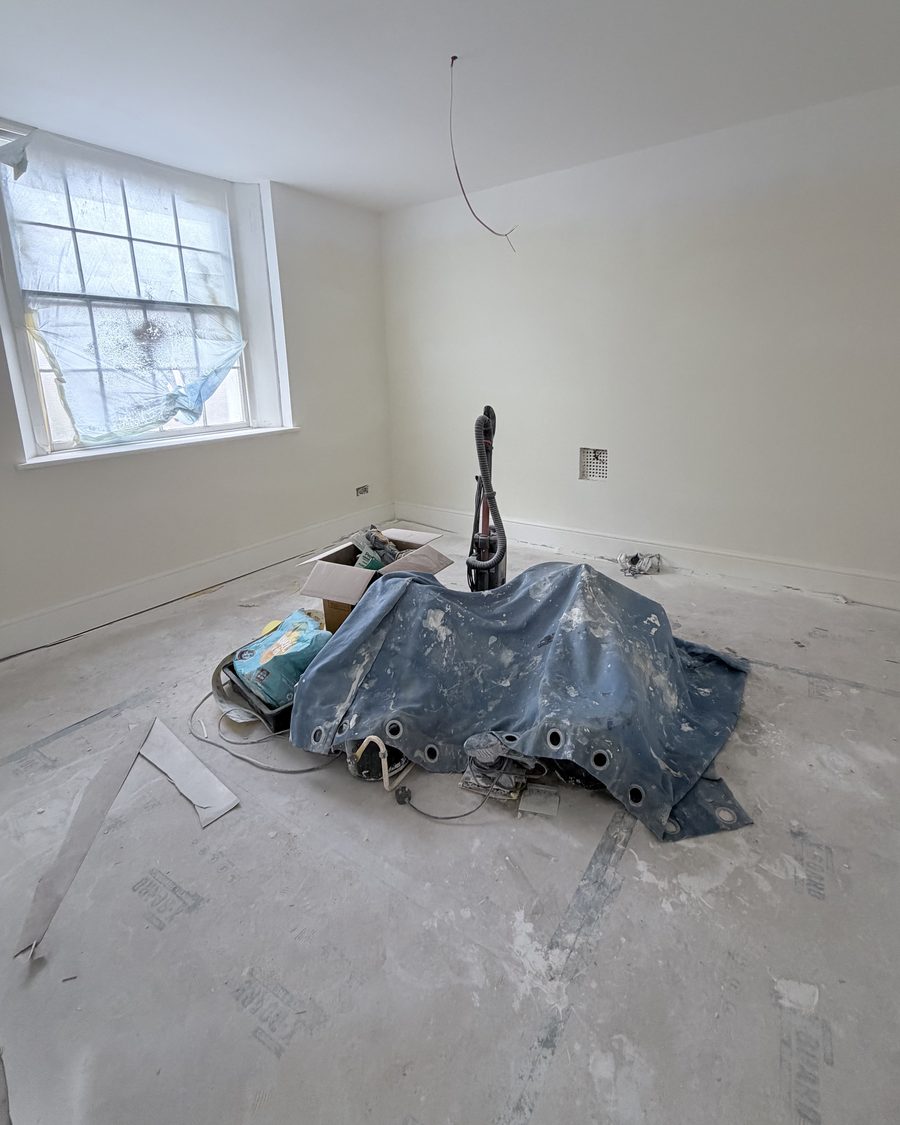 A stripped-back room with a sash window, part-way through the Chelsea Music Club fit-out
